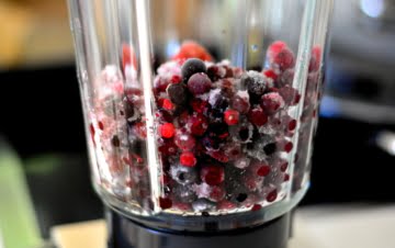 a blender jug full of berries