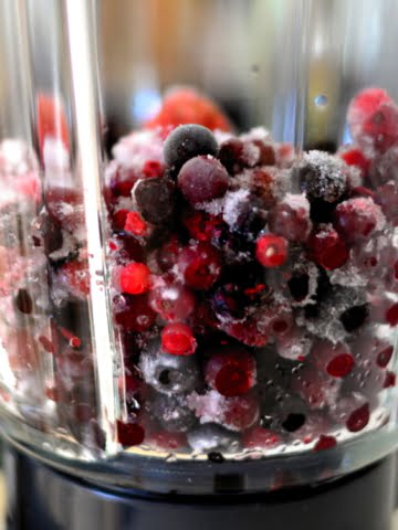 a blender jug full of berries