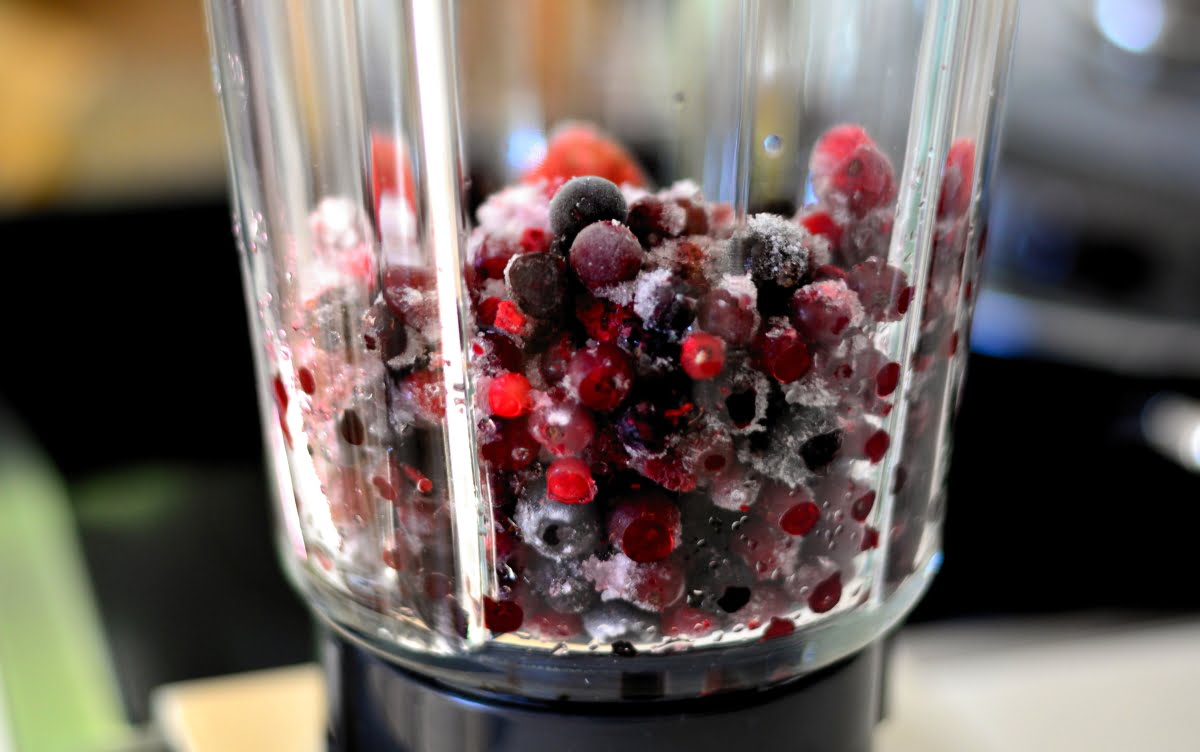 a blender jug full of berries