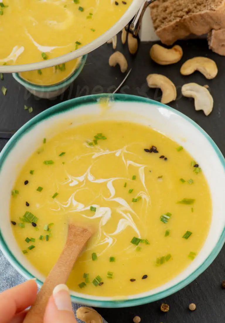zucchini creamy soup in a plate with a wooden spoon