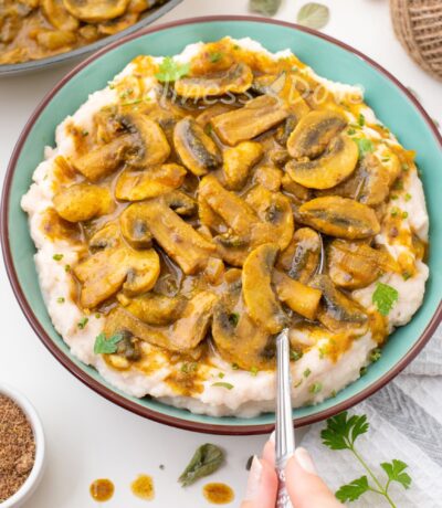 Curry mushrooms over white bean mash in a bowl