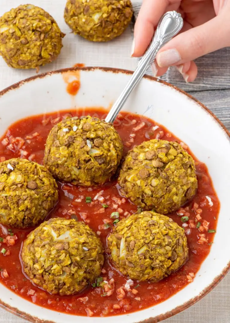 vegan meatballs on  a plate, a hand taking one out, 3/4 angle, zoomed out