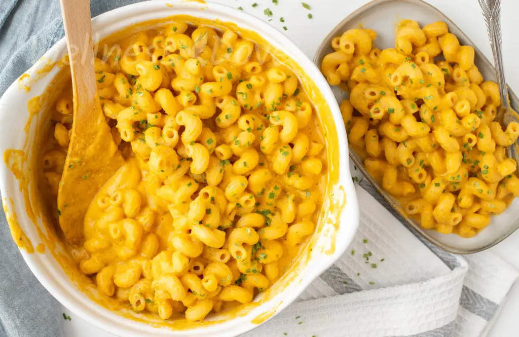 a casserole and a plate with vegan mac and cheese, overhead view