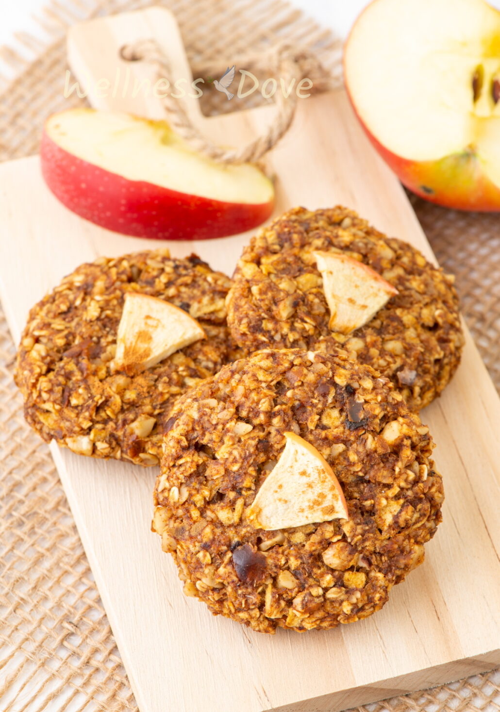 Three Apple Oatmeal Vegan Breakfast Cookies on a small chopping board.