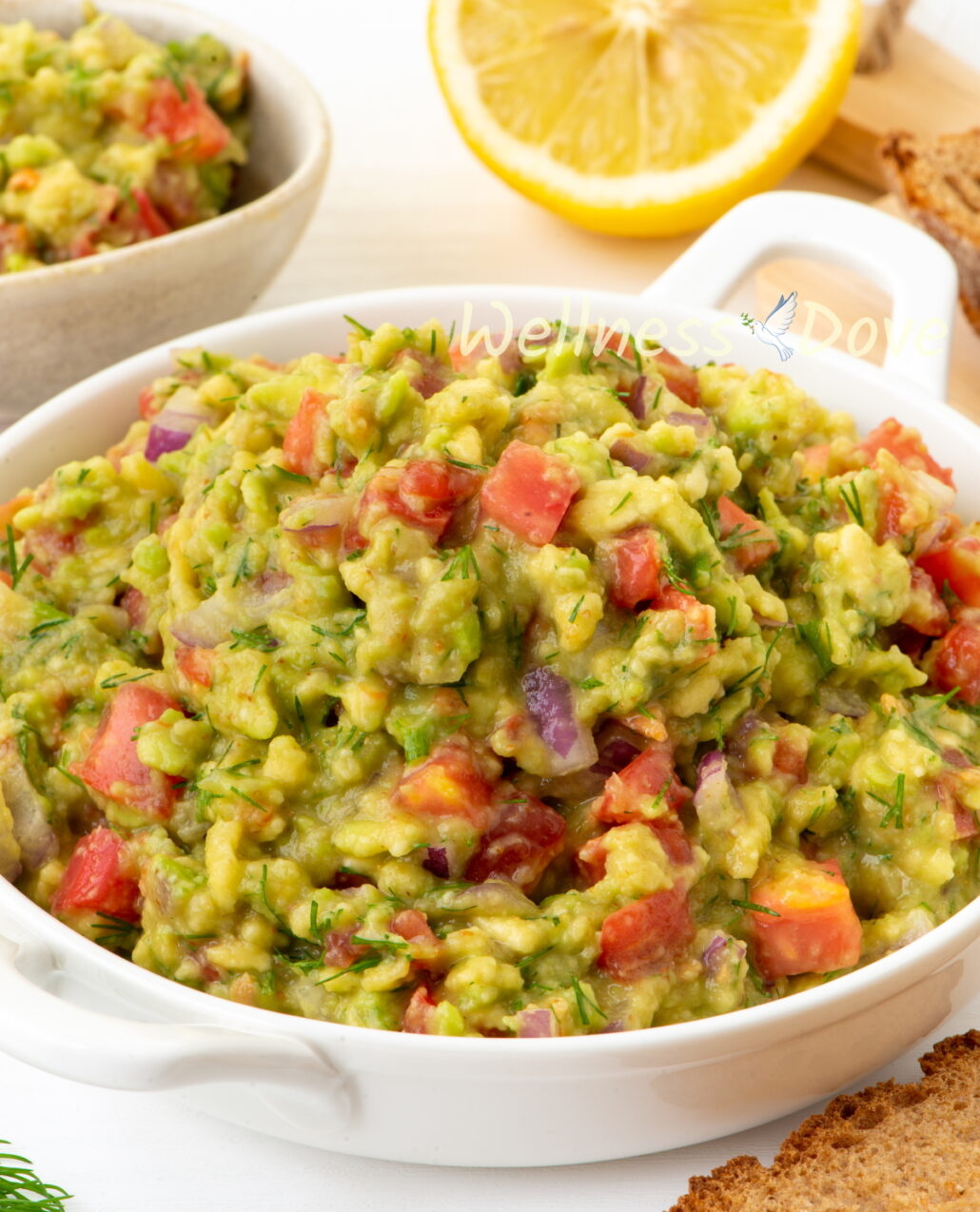 the vegan homemade guacamole  in a white bowl, 3/4 view