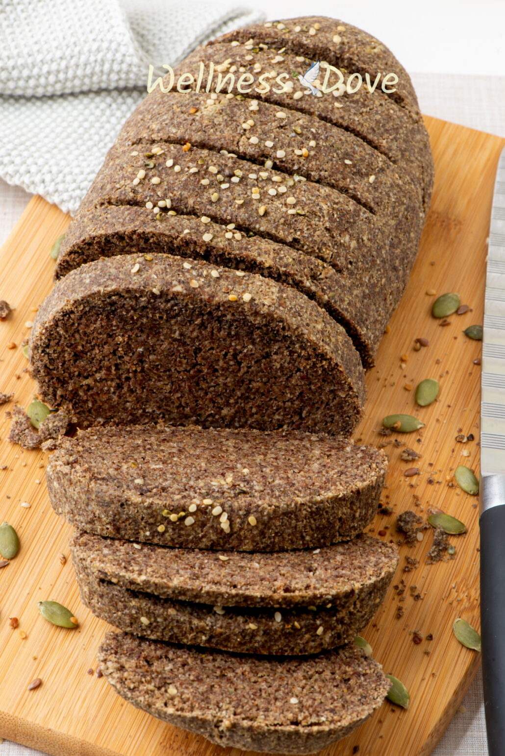 the vegan gluten free seeds bread on a chopping board with some slices cut. 