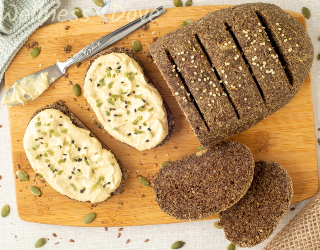 an overhead view of the vegan gluten free seeds bread - some slices are cut and have hummus on top of them