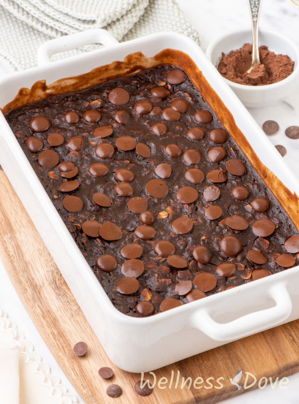 a 3/4 view of the Vegan Brownie Baked Oatmeal on top of a wooden chopping board