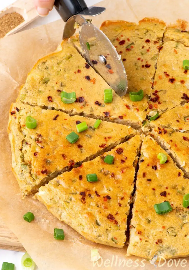 a 3/4 view of the easy gluten free chickpea flatbread while being cut into pieces