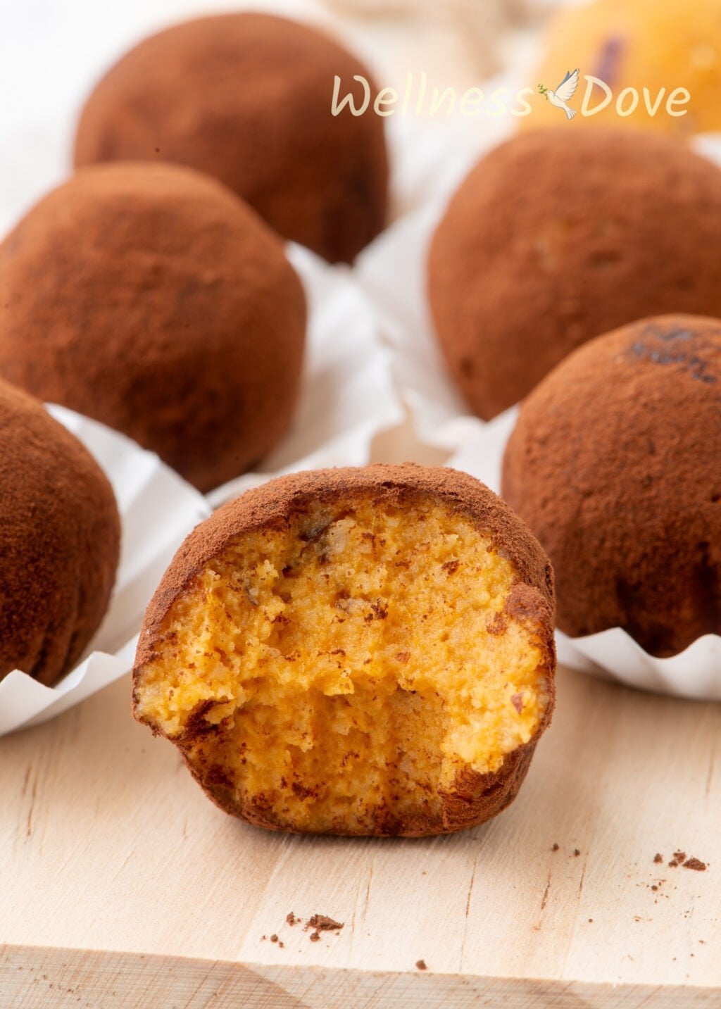 a close-up view of the vegan sweet potato vegan truffles, half of one is bitten off