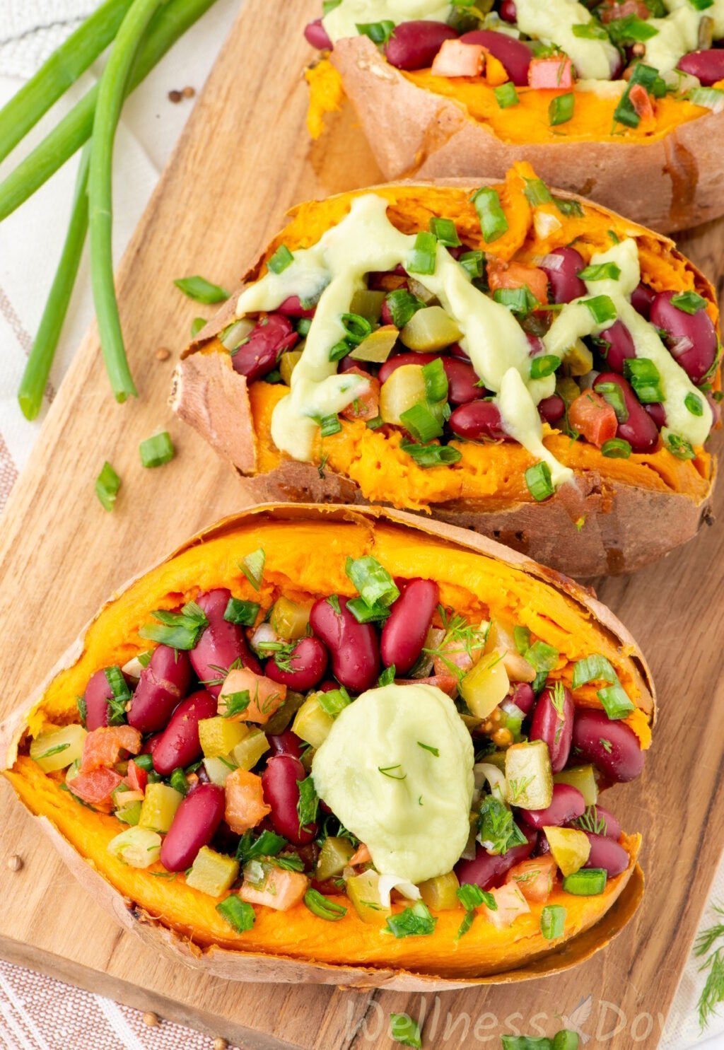 the bean stuffed vegan sweet potatoes on top of a chopping board