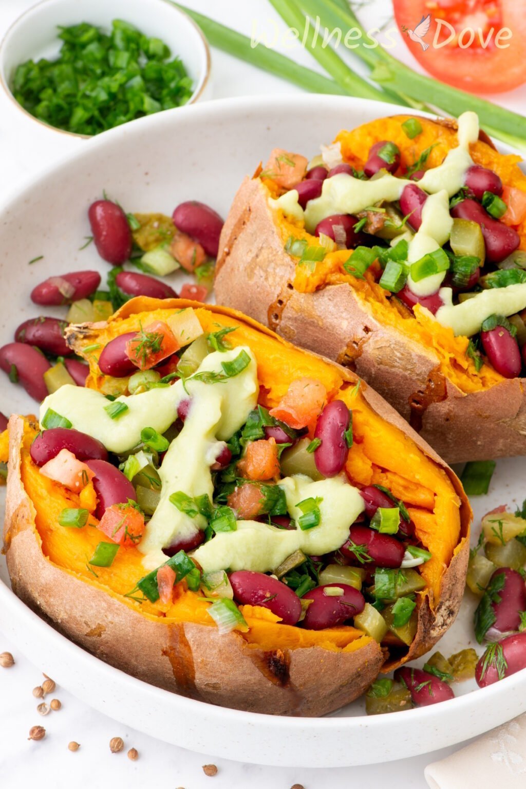 two of the bean stuffed vegan sweet potatoes in a large bowl