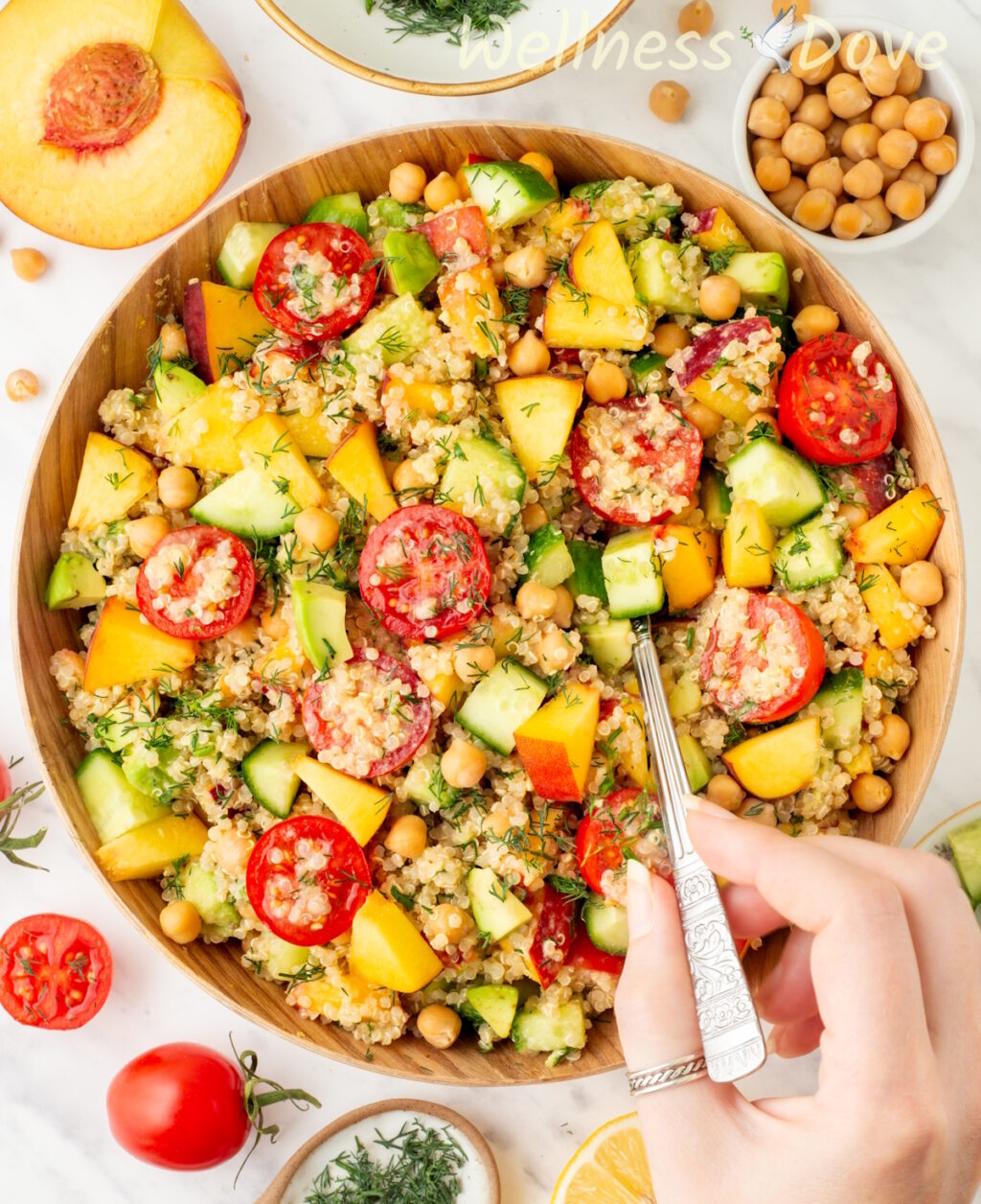 an overhead shot of the chickpea quinoa vegan salad while a hand is taking some out with a spoon