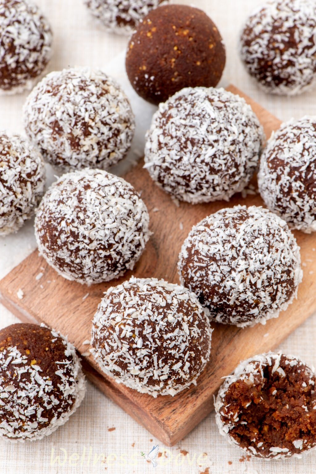 a close up view of the healthy vegan chickpea energy balls on a small rectangular wooden board
