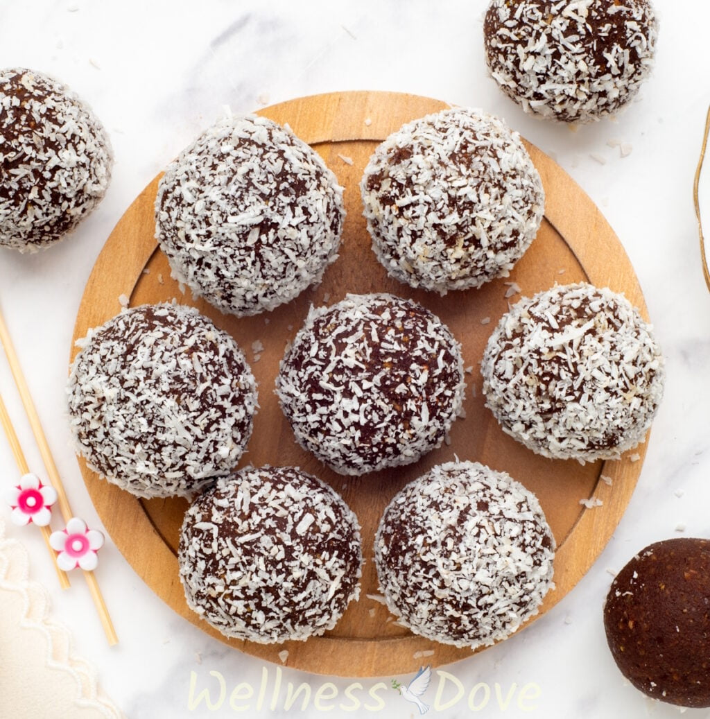 an overhead view of the healthy vegan chickpea energy balls on a small circular wooden board