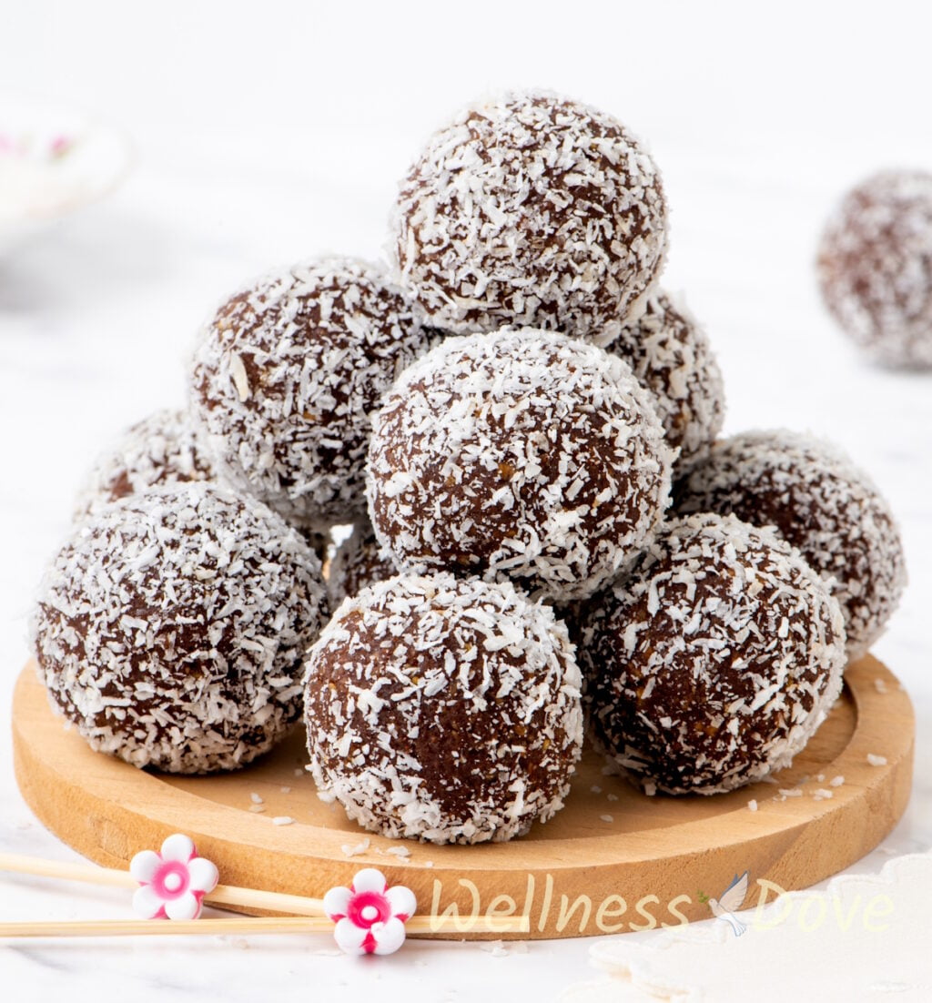 the healthy vegan chickpea energy balls on top of each other on a small wooden board