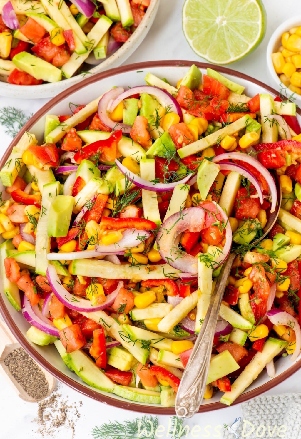 a slightly tilted overhead shot of the Refreshing Zucchini Vegan Salad in a bowl with a spoon in it