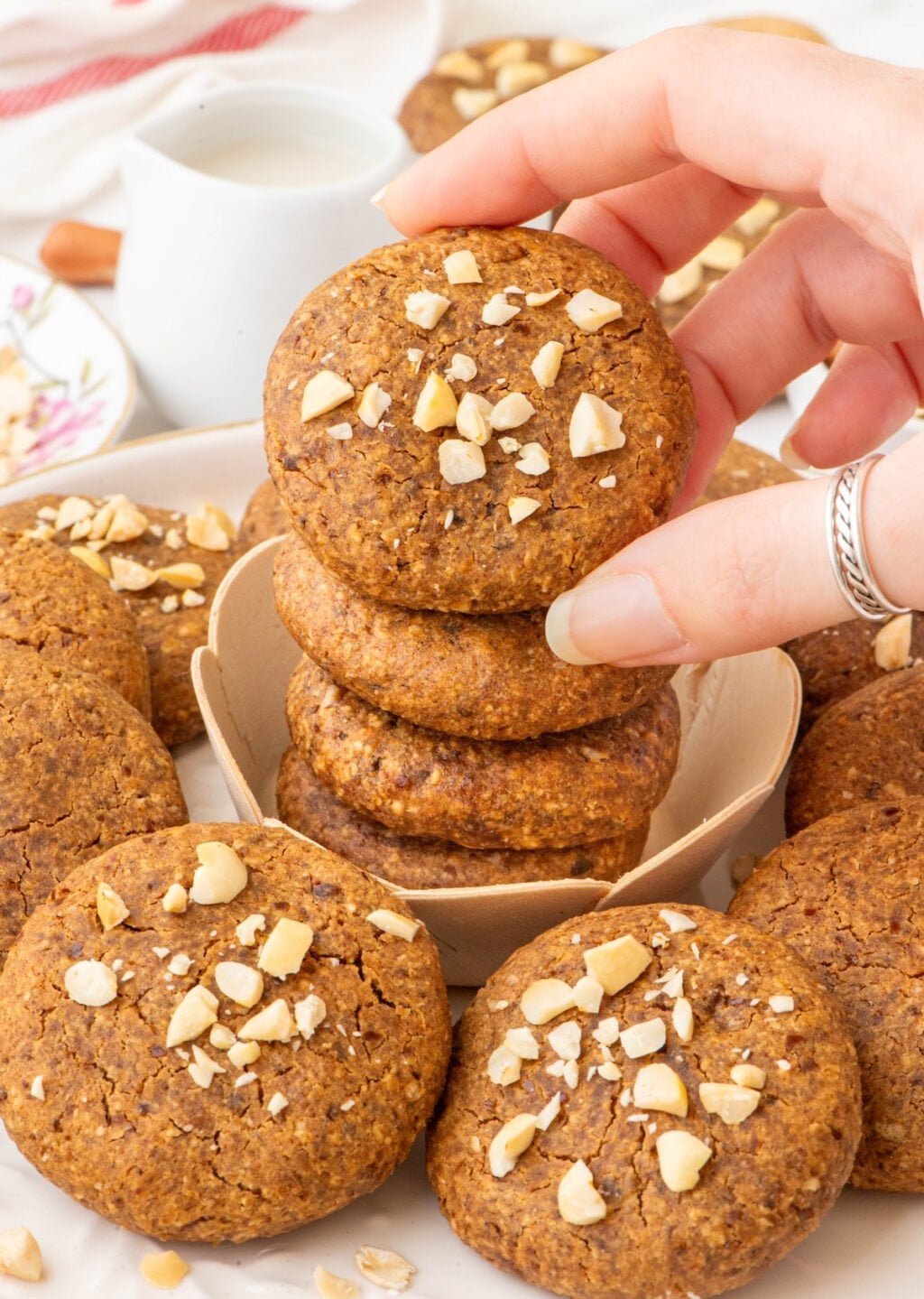 the Oatmeal Peanut Butter Vegan Cookies on top of each other and a hand is holding one