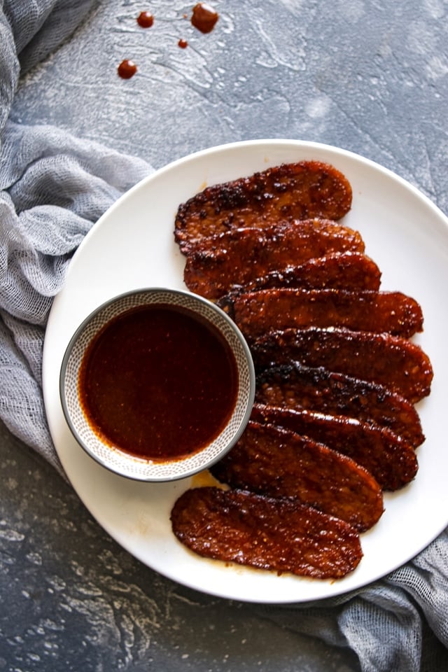 Smoky vegan tempeh bacon strips in a pan